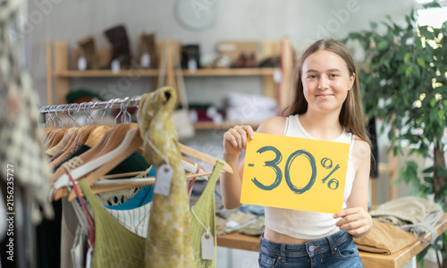 Photography Positive adolescent girl happily advertising summer discount sale in retail outl
