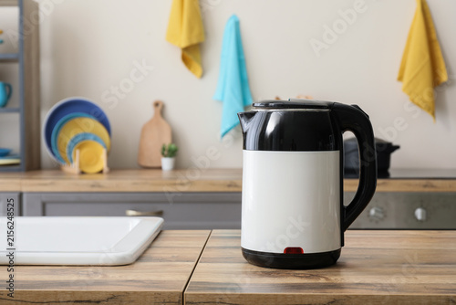 Konstfotografi Modern electric kettle with black and white design on a wooden kitchen counter,