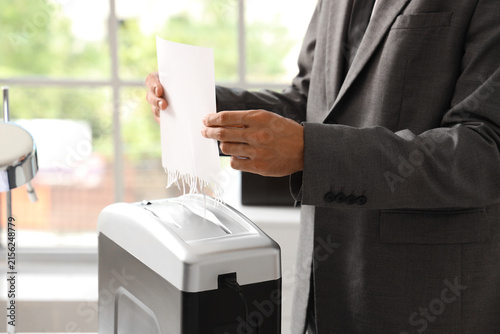 Obraz na plátně Businessman shredding confidential documents for data protection and privacy in