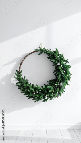 Minimalist Christmas wreath modern holiday decor evergreen branch silver ornament white wall bright shadow winter season festive decoration circle shape Christmas Concept