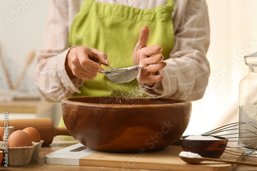 Woman sifting flour into bo...