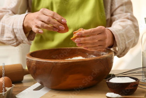Woman pouring raw egg into ...