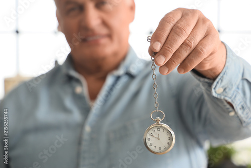 Obraz na plátně Male hypnotist with pocket watch in office
