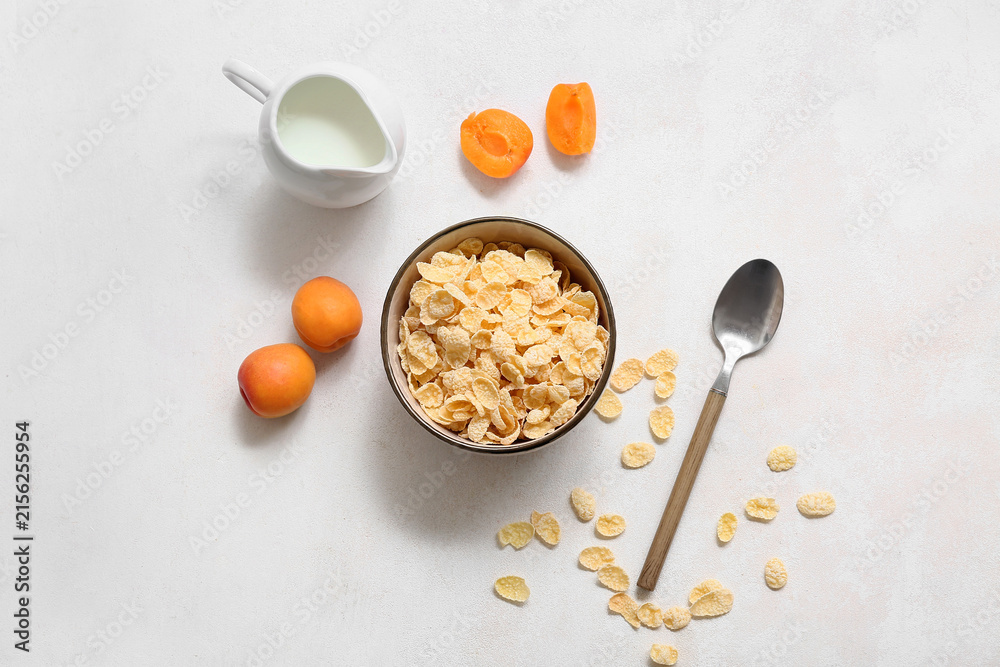 Fototapeta premium Apricots and bowl with cornflakes on white background