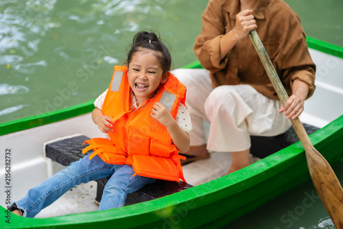 Cuadro en lienzo close-up of smiling preschool child girl in a life jacket aboard a rowboat