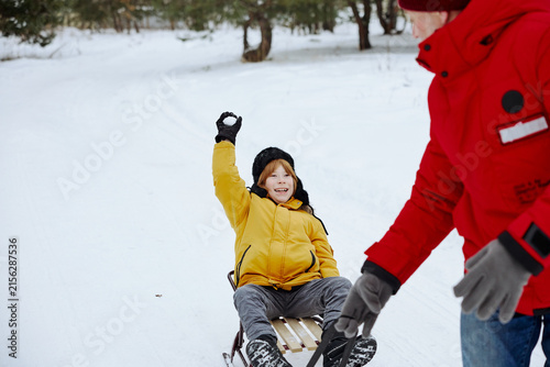 Canvastavla Grandfather and grandson sled riding during a winter outdoor adventure