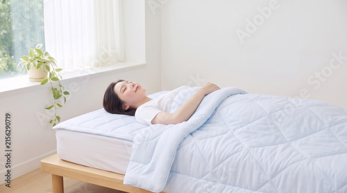 하늘색 이불을 덮고 편안히 누운 여성 · Woman Resting Under Light Blue Comforter in Bed