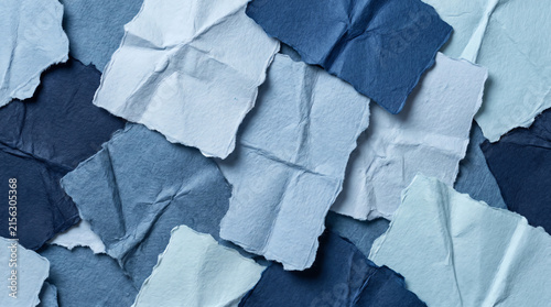 Textured background of torn and crumpled blue paper scraps