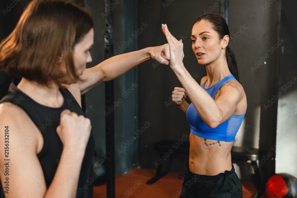 Fototapeta premium Two athletes practicing self-defense during training in a boxing gym