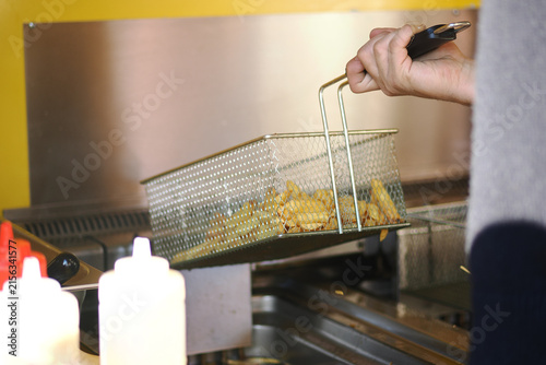 Cooking fries at a fast food restaurant kitchen