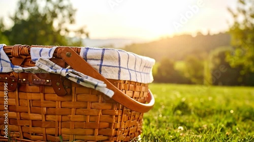 Picnic Basket in Summer Meadow at Sunset