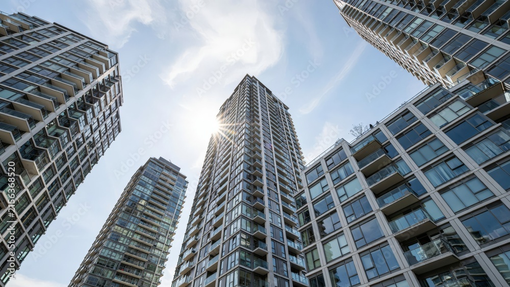 Fototapeta premium Low angle view of modern highrise apartment buildings against a blue sky