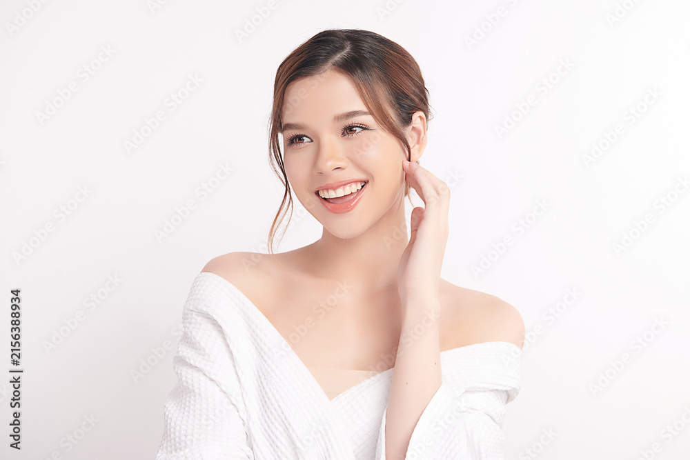 Naklejka premium A beautiful young Asian woman with clean, fresh skin against a white background. Skincare, facial treatment, cosmetology, beauty, and spa. An elegant portrait of an Asian woman.