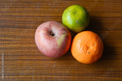 Fresh apples and oranges arranged on a rustic wooden table, showcasing vibrant colors and natural textures