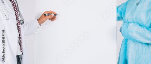 Doctor in White Coat Writing on White Background with Copy Space