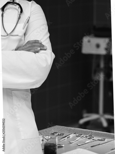 Doctor in White Coat with Crossed Arms in Black and White Medical Setting