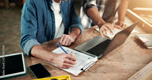 Hands, carpenter and laptop at factory with clipboard, research and pricing timber for production. People, checklist and pc at workshop for carpentry, quotation and team for manufacturing furniture
