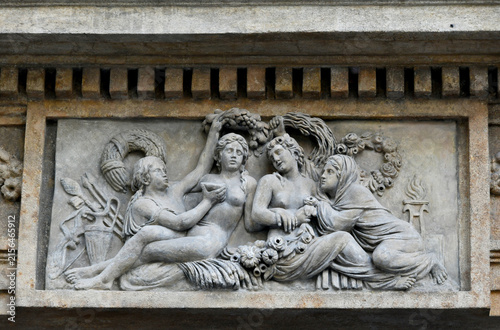 фотографія Classical stone relief carved on a building facade in Prague, portraying figures in mythological allegorical poses