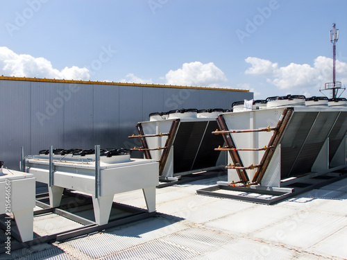 Industrial HVAC units installed on a warehouse rooftop under a clear blue sky