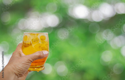 Holding a beer glass against a beautiful bokeh background.