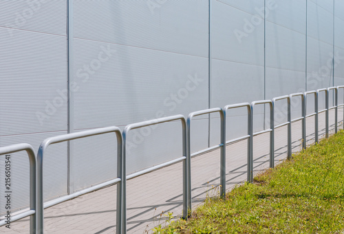 Modern industrial building exterior with metal safety railing and paved walkway