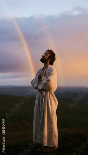 Man on Hilltop Finds Peace Under Double Rainbow Golden Hour Serene Landscape Photography