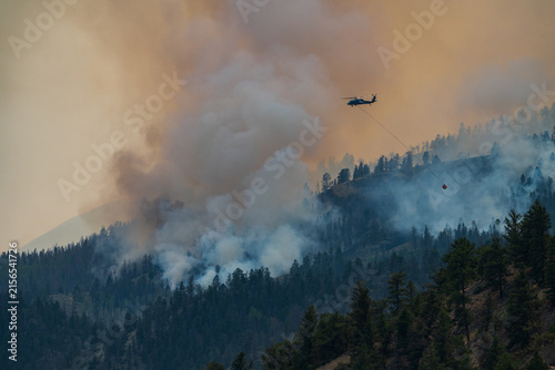 Firefighting helicopter battles smoky mountain wildfire