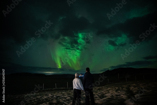Couple Silhouetted Against a Clear Vertical Aurora Curtain in Iceland