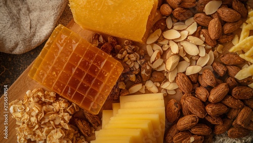Honeycomb, raw almonds, and sliced sharp cheddar on a wooden board
