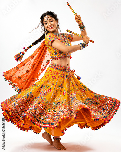 Vibrant Indian woman performing Garba dance with dandiya sticks in traditional festive attire