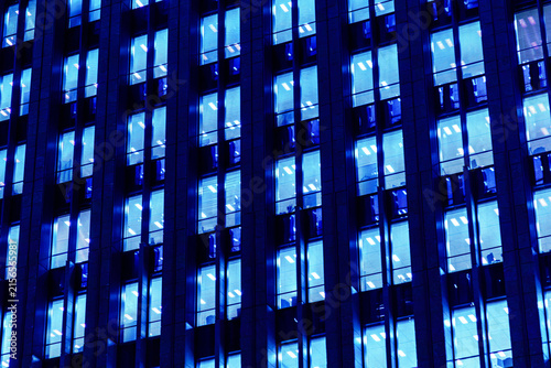 Cyber-blue geometric grid and vertical lines of modern office tower, perfect for digital technology background.