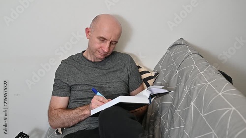 Focused mature man reading and highlighting book pages at home video HD Full