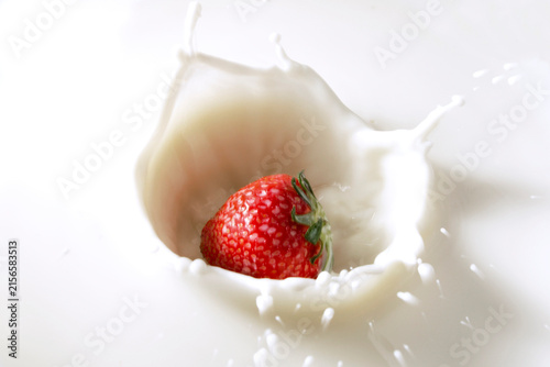 Strawberry splashing into milk