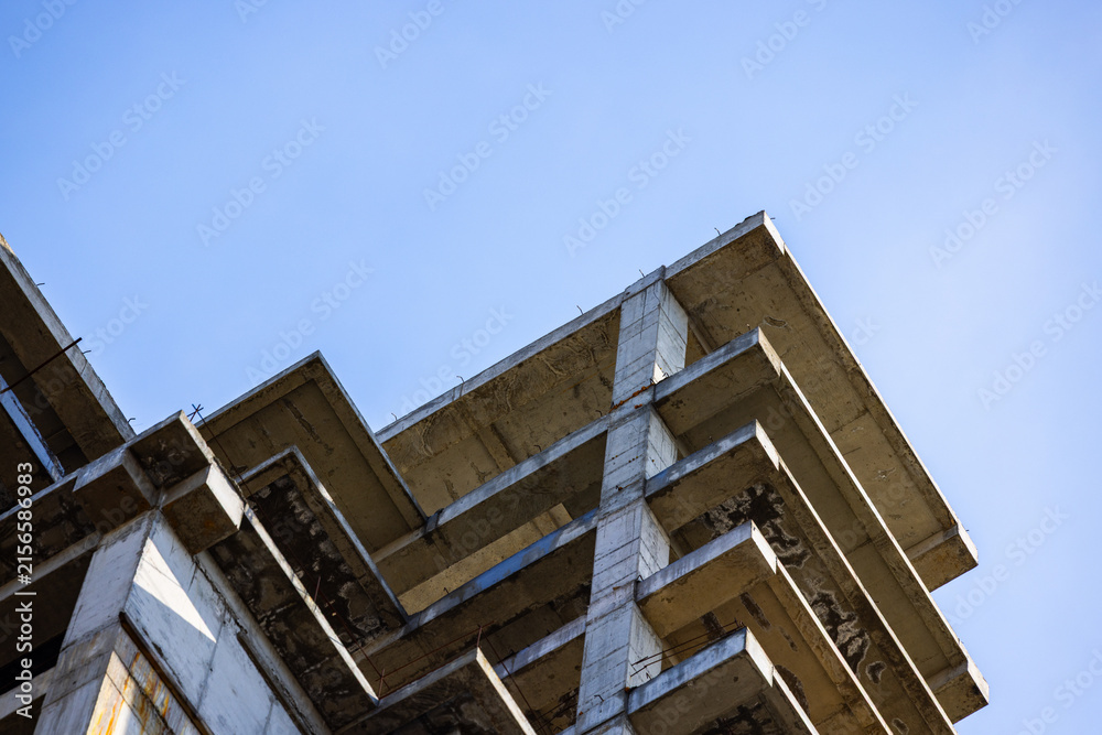 Fototapeta premium Unfinished Concrete Building Structure Against Blue Sky