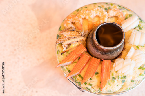 Thai steamed egg custard topped with crab sticks, squidม crab and shrimp served in Thai style stainless steel hot pot