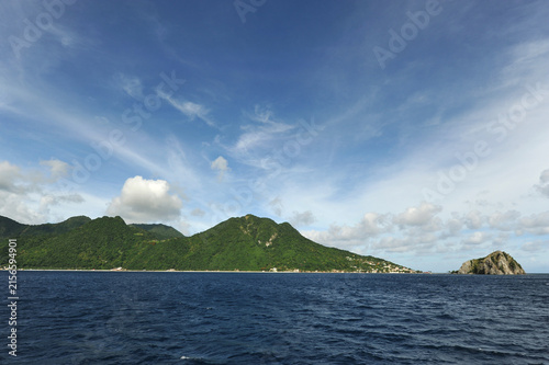Dominica, Roseau, rock which southern tip of the island and lush green hills in background