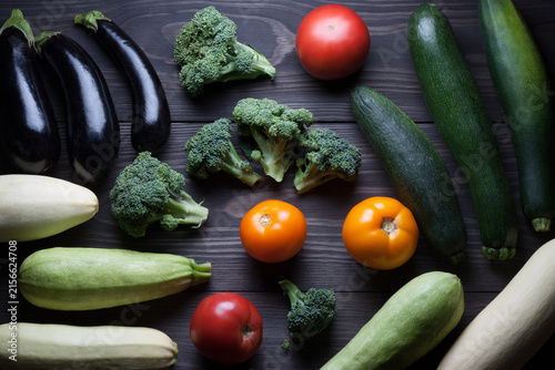 Healthy eating background. Fresh vegetables on wooden table (zucchini, eggplant, tomatoes, broccoli)