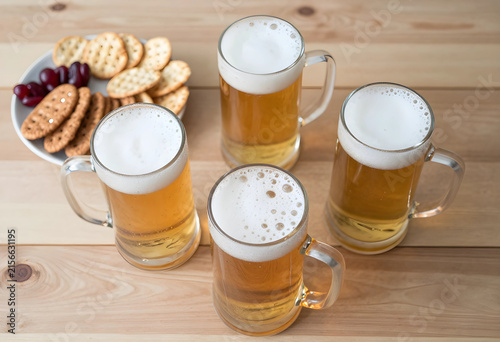 Four mugs of golden beer wi...