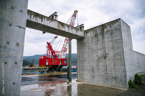 Crane vessel seen through seawall opening on rainy day