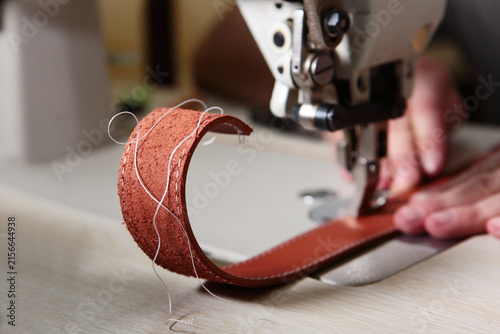 Fotografie Close-up of sewing red-brown leather on sewing machine: double stitching with wh