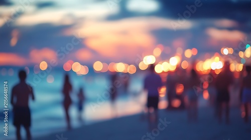 Blurred sunset beach scene with silhouettes of people enjoying the evening.