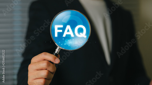 Business professional holding magnifying glass with FAQ text for customer support and inquiry