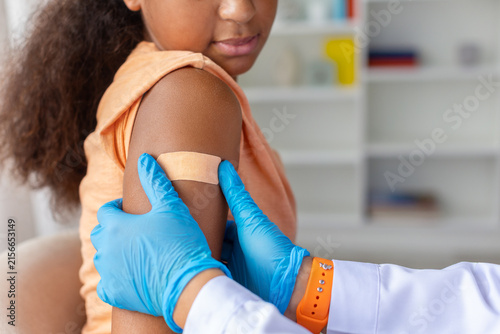 Cuadro en lienzo Closeup of young Black girls upper arm with adhesive bandage after vaccination a