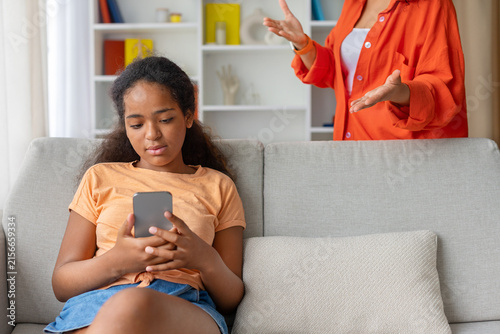Canvastavla Teenage girl ignoring mothers gestures while focused on her smartphone, generati