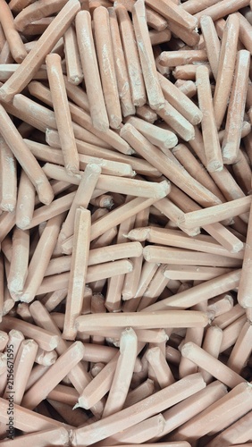 Bulk Pile of Unfinished Wooden Dowel Pins for Furniture Manufacturing and DIY Projects