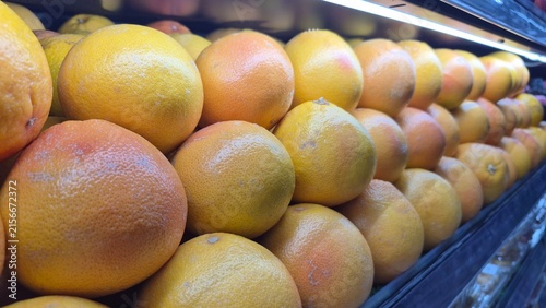 Fresh Grapefruits Stacked Neatly on a Grocery Store Shelf for Healthy Eating and Produce Marketing