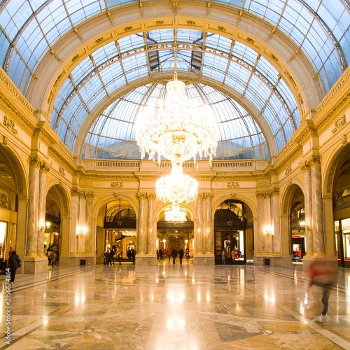 Grand interior of historic European shopping arcade at night.