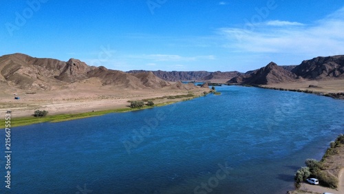 Aerial view of Ili river flowing through rocky canyon and desert landscape