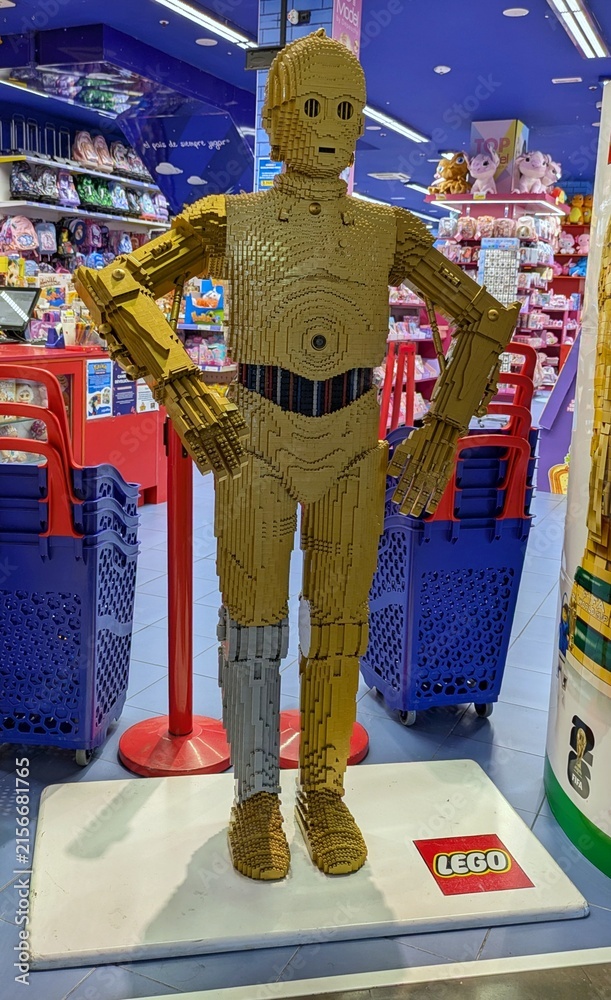 Fototapeta premium Enorme figura de exposición del robot C-3PO de Star Wars, construido con ladrillos de Lego, en la entrada de una juguetería Juguettos de Madrid, España, 3 de junio de 2026