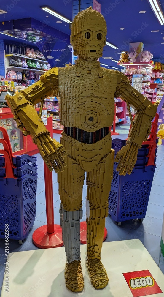 Fototapeta premium Enorme figura de exposición del robot C-3PO de Star Wars, construido con ladrillos de Lego, en la entrada de una juguetería Juguettos de Madrid, España, 3 de junio de 2026